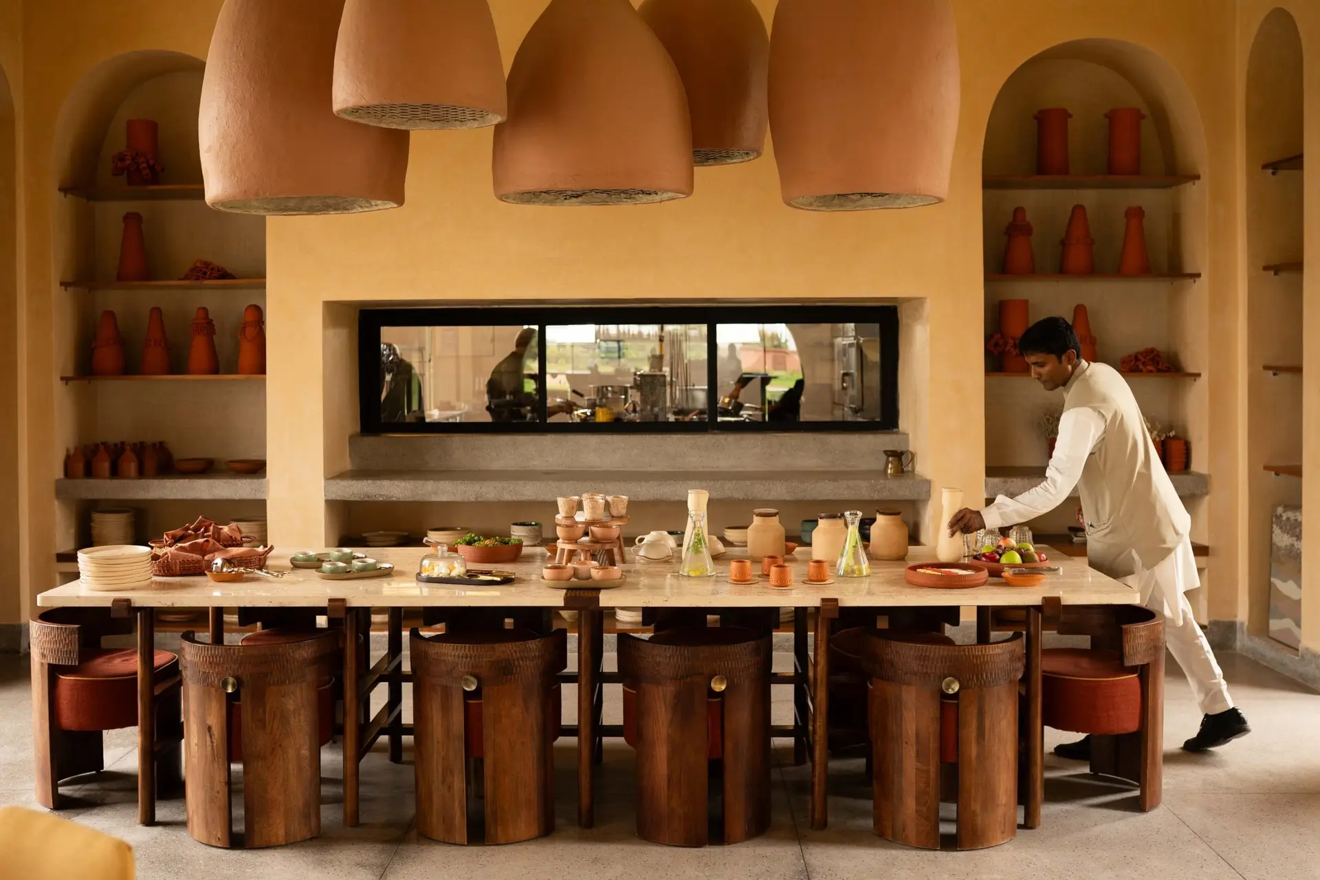 The Samaa dining hall set under terracotta pendant lamps